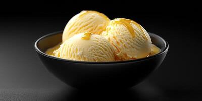 Creamy vanilla ice cream topped with golden syrup served in a black bowl photo