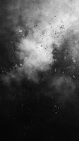 Textured black and white abstract cloud formation with scattered particles in a cosmic setting photo