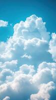 Bright fluffy clouds float against a clear blue sky in midday sunlight photo