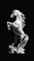 Majestic white horse sculpture rearing up against a dark background depicting grace and strength photo