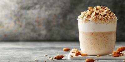 Creamy oat and yogurt parfait topped with nuts and seeds served in a clear glass container photo