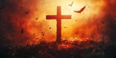 Cross illuminated by a fiery sunset with birds flying in the background during evening hours photo
