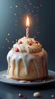 Sweet celebration cake with icing and candle glowing in dark background photo