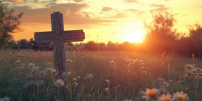 Cross standing in a field of daisies at sunset with golden light illuminating the landscape photo