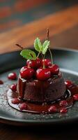 Decadent chocolate cake with fresh cherries and mint served on a black plate in a cozy setting photo