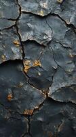 Cracked and weathered black surface with golden accents highlighting the details in the texture photo