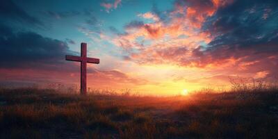 Stunning sunset over a grassy field with a wooden cross silhouette against a colorful sky photo