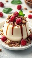 Creamy dessert topped with fresh raspberries and nuts served on a white plate in a beautifully arranged setting photo