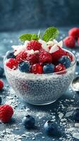 Delicious chia seed pudding topped with fresh berries and coconut flakes served on a blue background photo