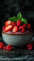 Fresh berries topped with mint in a textured bowl create a vibrant dessert display photo