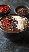 Delicious smoothie bowl topped with goji berries, dark chocolate chips, and coconut flakes in a stylish bowl photo
