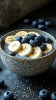 Healthy chia seed pudding topped with bananas and blueberries in a rustic bowl photo