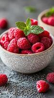 Fresh raspberries garnished with mint leaves in a decorative bowl on a textured surface photo