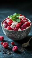 Fresh raspberry yogurt bowl with coconut flakes and mint on a dark background photo