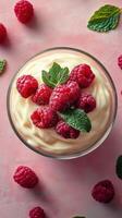 Delicious raspberry dessert with cream and mint leaves on a pink background photo
