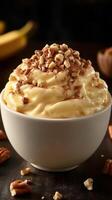 Delicious creamy dessert topped with crushed nuts served in a white bowl photo