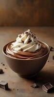 Rich chocolate dessert topped with whipped cream and chocolate shavings in a rustic bowl photo