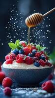 Fresh berries topped with honey and mint create a vibrant dessert in a stylish bowl photo