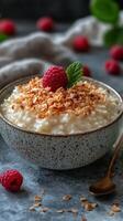 Raspberry coconut pudding served in a rustic bowl with fresh berries on a dark background photo