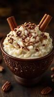 Creamy rice pudding topped with pecans and cinnamon served in a decorative bowl photo
