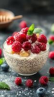 Delicious dessert bowl with chia seeds, fresh raspberries, and mint on a dark background photo