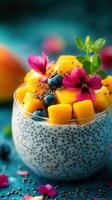 Colorful chia seed pudding topped with mango, blueberries, and edible flowers on a vibrant blue background photo