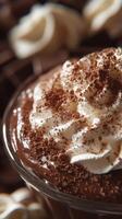 Rich chocolate dessert topped with whipped cream and cocoa powder in a decorative setting photo