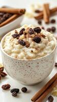 Delicious bowl of creamy rice pudding topped with cinnamon, raisins, and cocoa beans on a rustic table photo