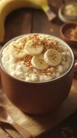 Warm bowl of oatmeal topped with banana slices and granola served on a wooden table in a cozy kitchen setting photo