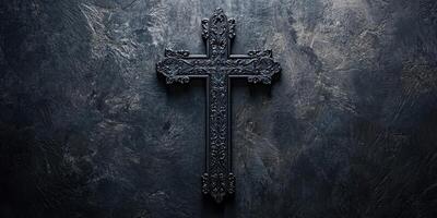 Intricately designed black cross set against a textured dark background during a contemplative moment photo
