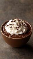Creamy chocolate dessert topped with whipped cream and chocolate shavings served in a brown bowl photo