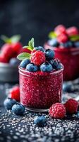 Fresh berry chia seed pudding served in glass jars, garnished with mint leaves on a dark background photo