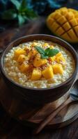 Creamy mango rice pudding served in a wooden bowl with mint garnish on a rustic table photo