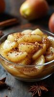 Sliced apples sprinkled with cinnamon and served in a glass bowl at a cozy kitchen setting during autumn photo