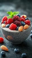 Fresh berry and almond dessert in a textured bowl on a dark background photo