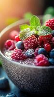 Fresh berry bowl with mint and chia seeds garnished in a textured bowl during golden hour photo