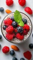 Delicious chia pudding topped with fresh berries and mint on a light background photo