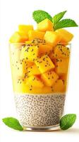 Healthy mango chia pudding served in a clear glass with fresh mint leaves photo