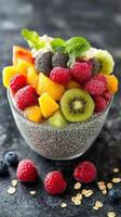 Delicious chia seed pudding topped with fresh berries and tropical fruits served in a glass bowl photo