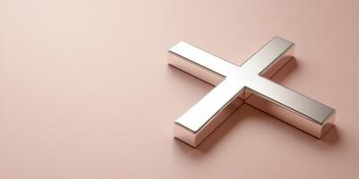 Metallic cross placed on a soft pink surface highlighting its reflective surface and symmetry during bright lighting conditions photo