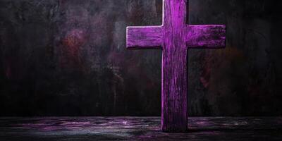 Purple wooden cross positioned on a dark surface against a textured background with mystic lighting effects photo