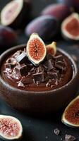 Delicious chocolate mousse topped with fresh figs and chocolate chunks in a dark bowl photo