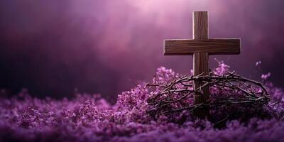 Beautiful wooden cross surrounded by purple flowers and twigs in serene setting during early evening light photo