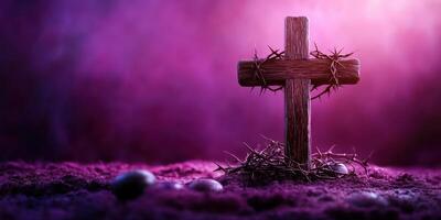 Wooden cross adorned with thorns and stones surrounded by a purple mist in a dimly lit setting photo