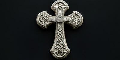 Intricate stone cross with Celtic designs displayed on a dark background photo