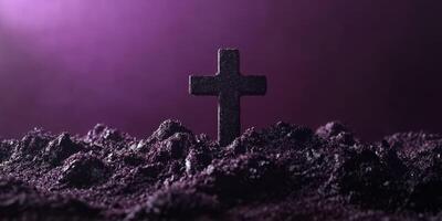 Mysterious black cross stands prominently amid dark soil with a purple backdrop photo