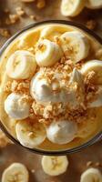 Delicious banana pudding topped with whipped cream and crushed cookies in a glass bowl at a cozy kitchen setting photo