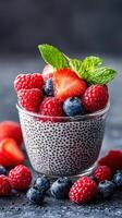 Delicious chia pudding topped with fresh berries in a glass cup photo