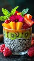 Colorful fruit salad with chia seeds in a glass bowl garnished with mint in a kitchen setting photo