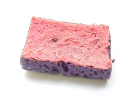 Closeup of a wellused, textured cleaning sponge. Its worn pink and purple layers show signs of hard work, symbolizing resilience and the passage of time. photo